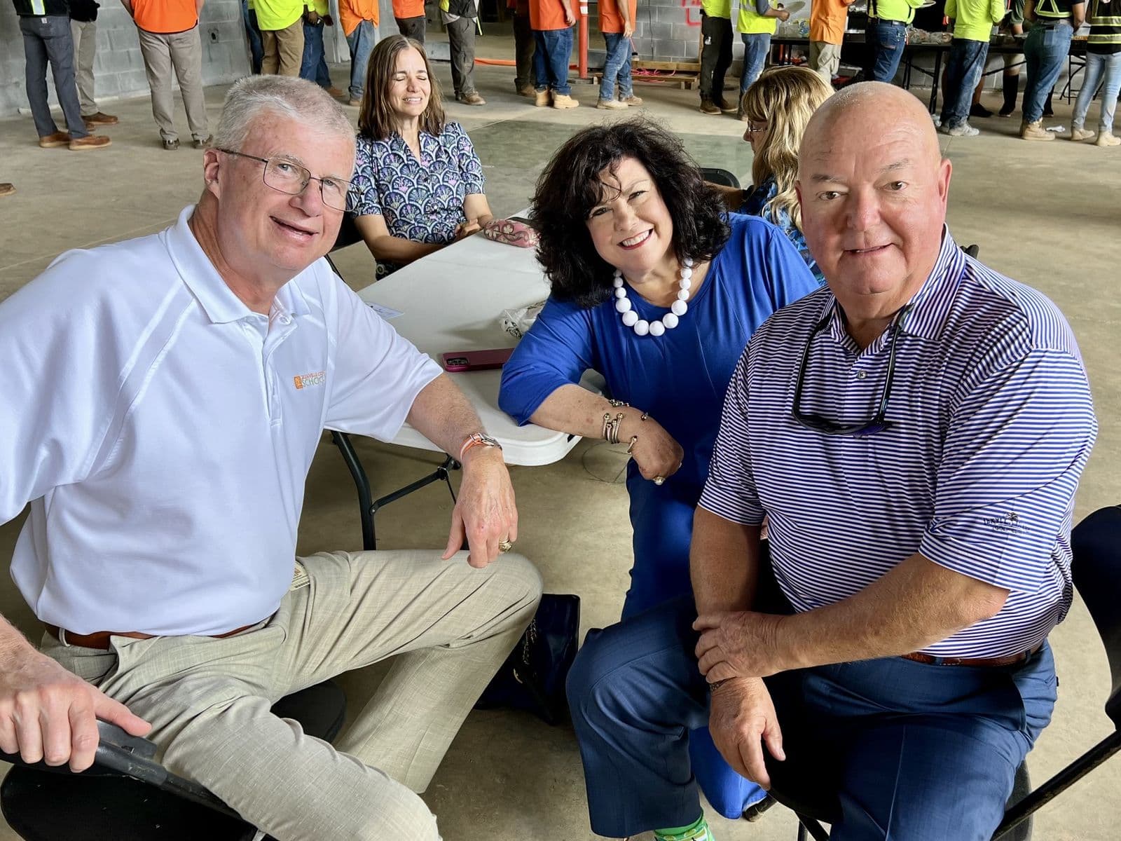 Chuck Saylors seated with others at a construction site.
