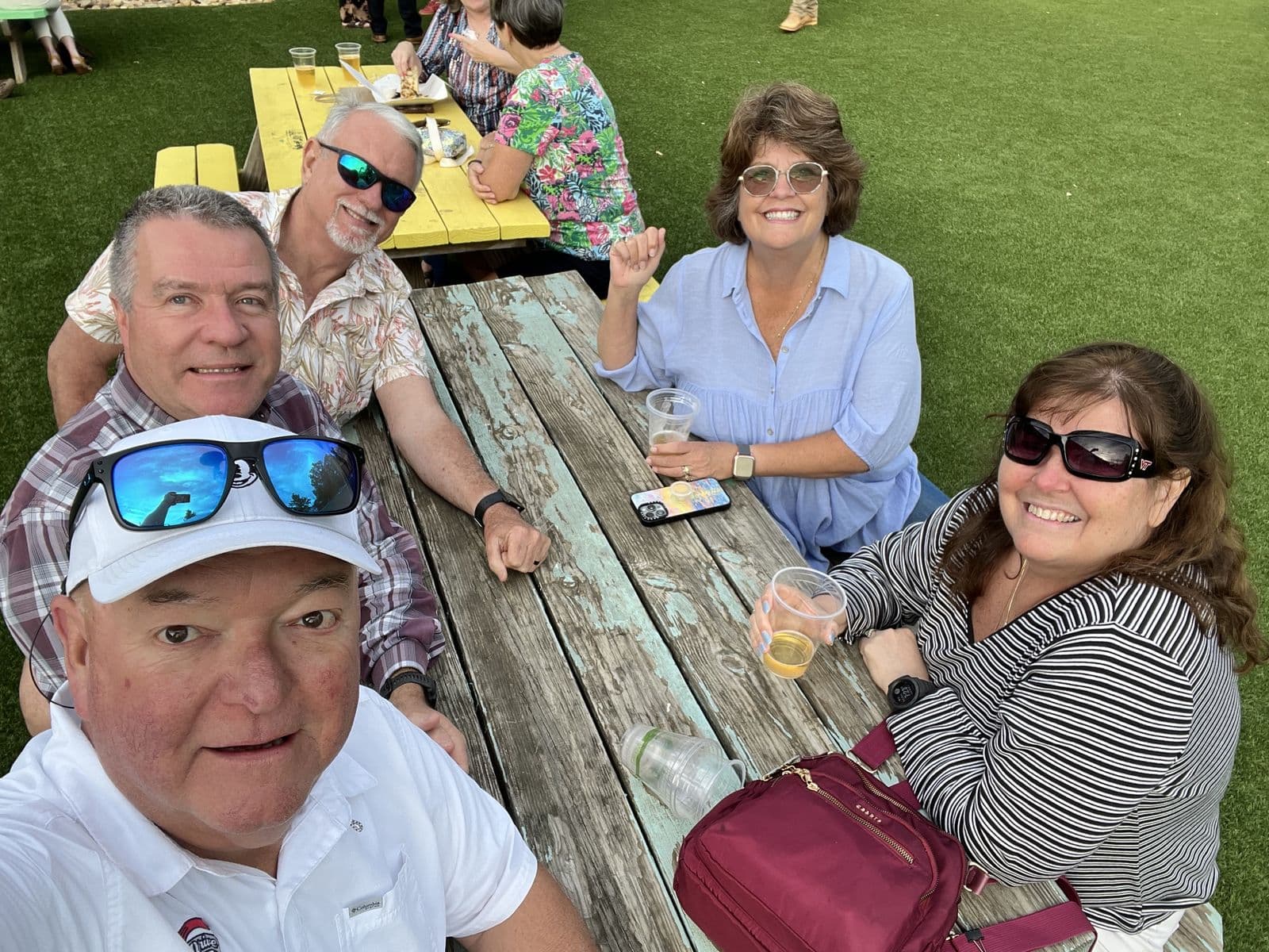 Chuck Saylors with friends at an outdoor picnic table.