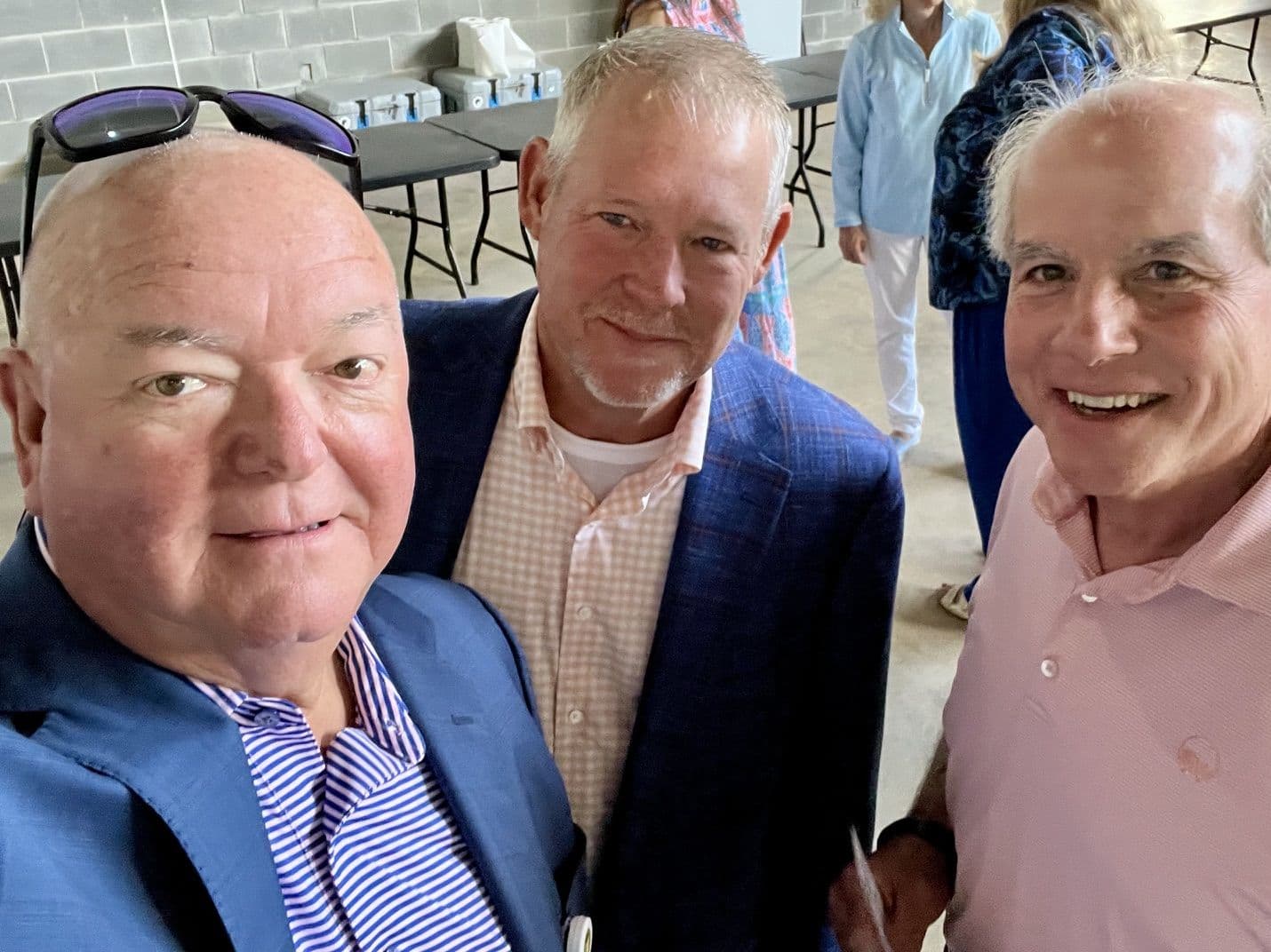 Chuck Saylors with two men at an outdoor gathering.